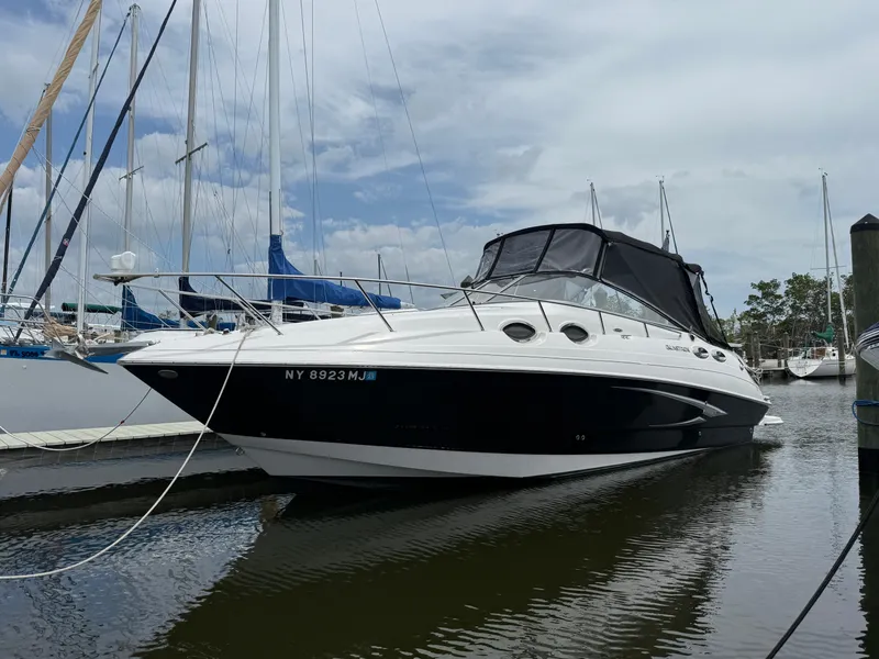 The Image of 2014 Glastron GS 289 boat docked in marina, featuring sleek design and black canopy. - 1