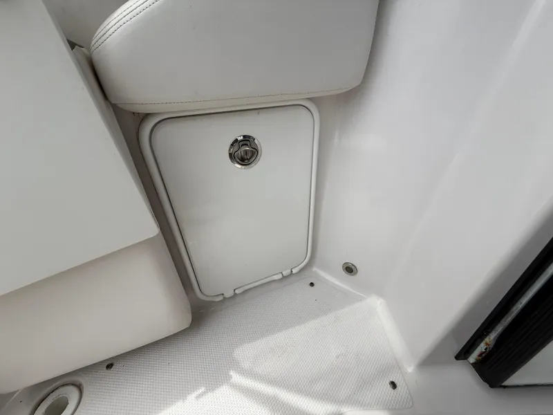 Slide: The Image of 2014 Glastron GS 289 boat interior storage compartment with white seating. - 11