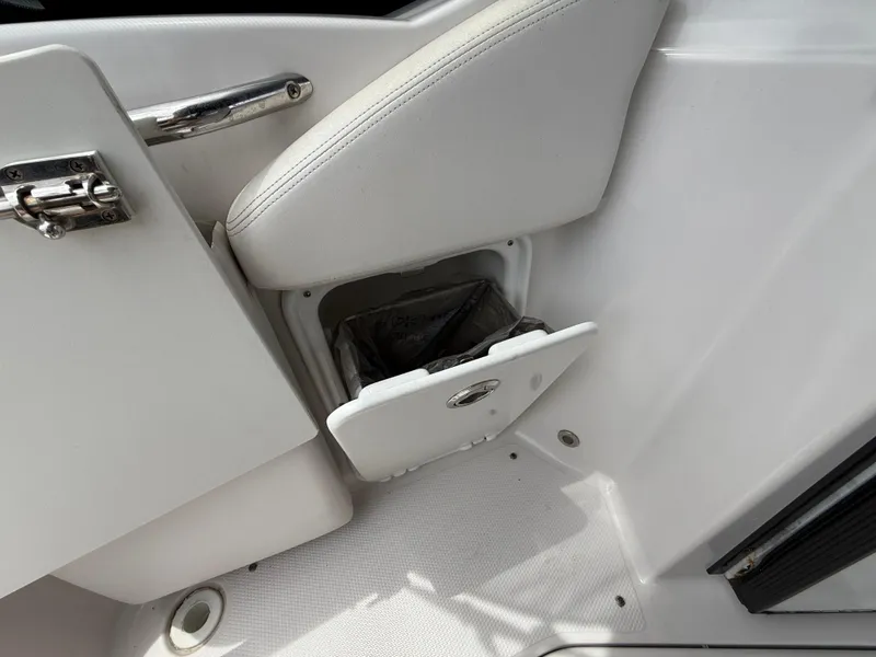 Slide: The Image of 2014 Glastron GS 289 boat interior with open storage compartment and white seating. - 12