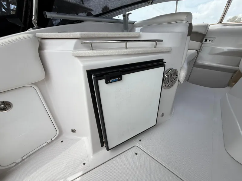 Slide: The Image of 2014 Glastron GS 289 boat interior with mini fridge and seating area. - 13
