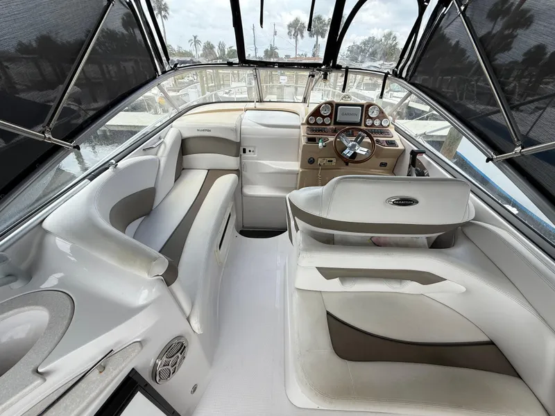 Slide: The Image of 2014 Glastron GS 289 boat interior with helm, seating, and canopy. - 16