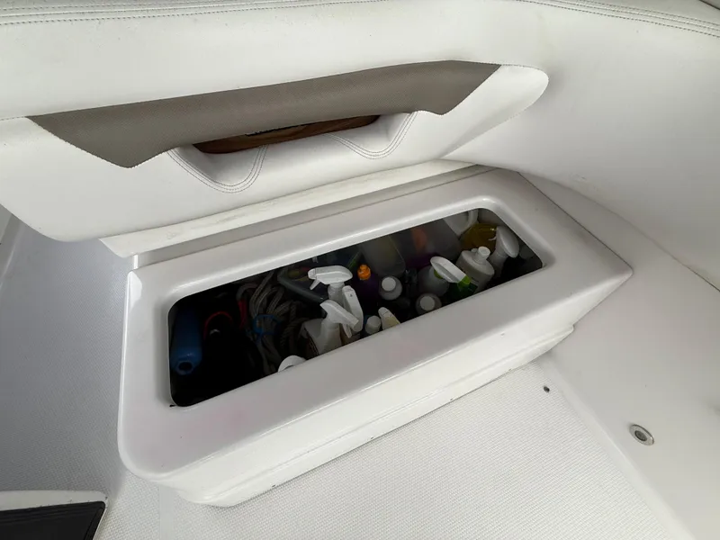 Slide: The Image of Storage compartment on 2014 Glastron GS 289 boat, containing various items. - 19