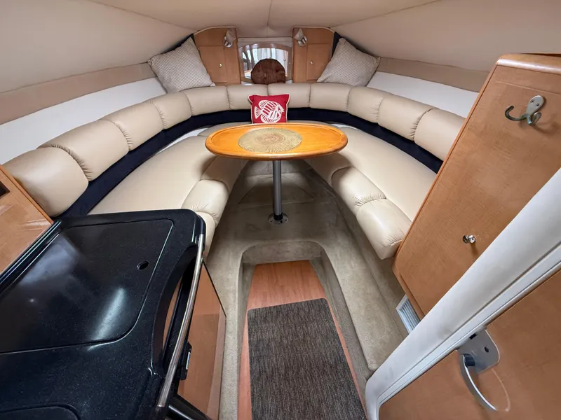 Slide: The Image of 2014 Glastron GS 289 boat interior with beige seating and wooden table. - 31