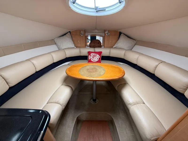 Slide: The Image of 2014 Glastron GS 289 cabin interior with beige seating and a central wooden table. - 32