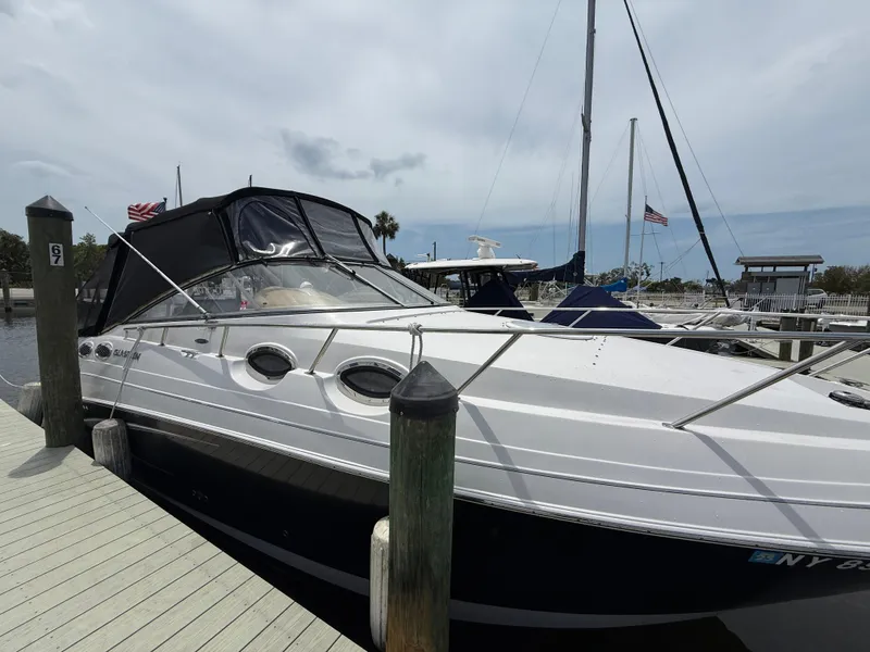 Slide: The Image of 2014 Glastron GS 289 boat docked at marina with flags in background. - 4