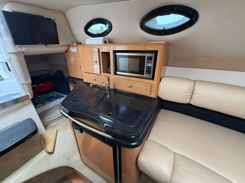 Slide: The Image of Interior of 2014 Glastron GS 289 boat with kitchenette and seating area. - 44