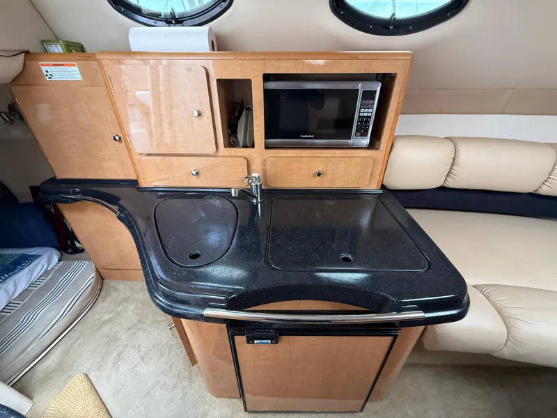 Slide: The Image of 2014 Glastron GS 289 boat interior with kitchenette, sink, and microwave. - 45