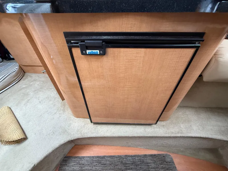 Slide: The Image of 2014 Glastron GS 289 interior with compact wooden cabinet and carpeted flooring. - 48