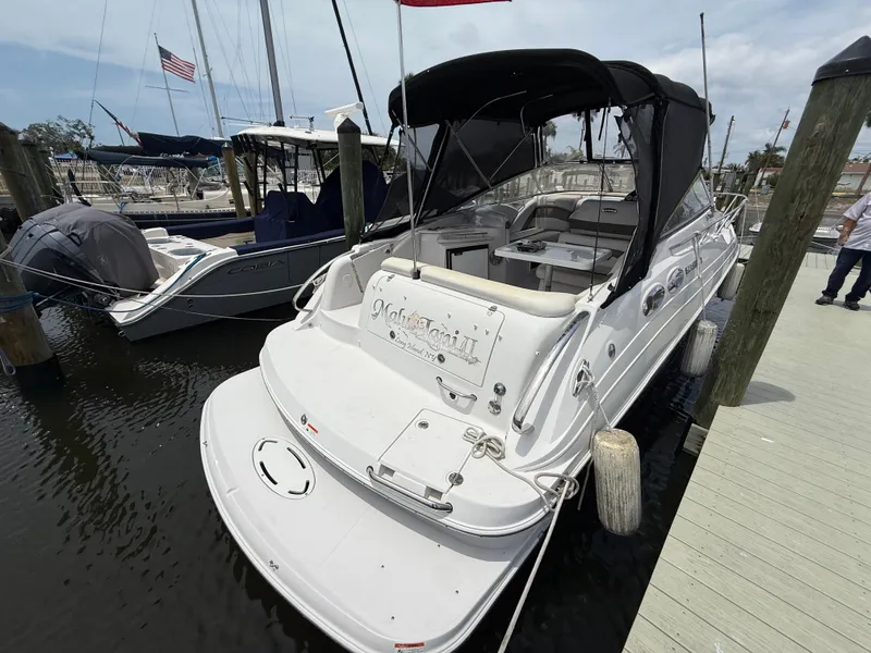Slide: The Image of 2014 Glastron GS 289 boat docked at marina, featuring sleek design and black canopy. - 6