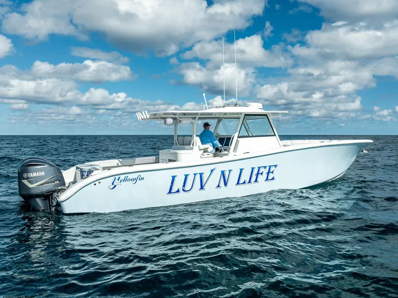 Slide: The Image of 2018 Yellowfin 42 boat named "LUV N LIFE" on open water under cloudy sky. - 17