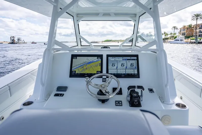 Slide: The Image of 2018 Yellowfin 42 boat dashboard with dual navigation screens on open water. - 19