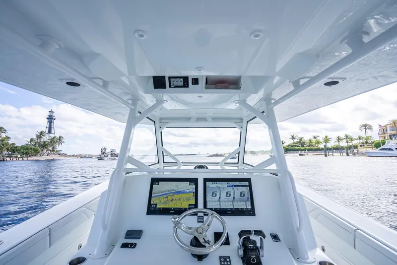 Slide: The Image of 2018 Yellowfin 42 boat dashboard with navigation screens, steering wheel, and ocean view. - 21