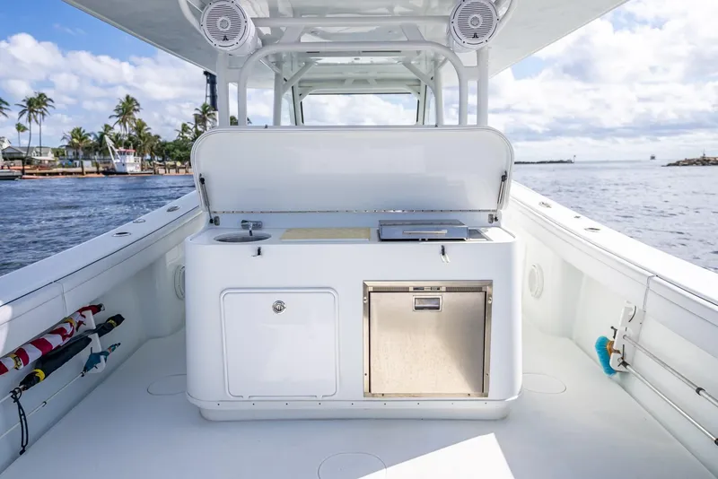 Slide: The Image of 2018 Yellowfin 42 boat with open deck, featuring a built-in kitchenette, on a sunny day. - 32