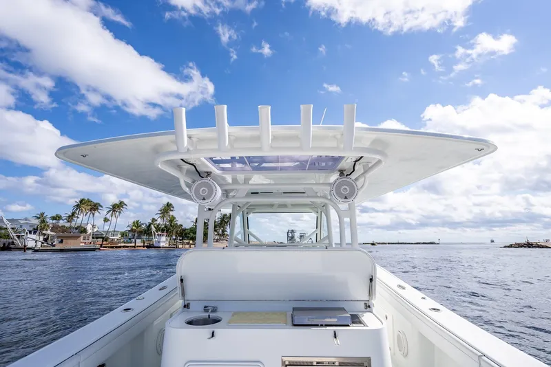 Slide: The Image of 2018 Yellowfin 42 boat on water, clear sky, palm trees in background. - 33