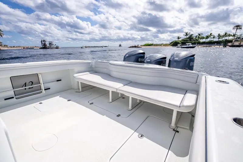 Slide: The Image of 2018 Yellowfin 42 boat with spacious deck and triple outboard motors on a sunny day. - 37