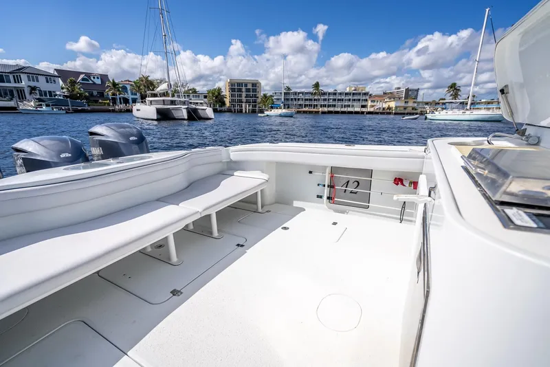 Slide: The Image of 2018 Yellowfin 42 boat with spacious deck, docked in a scenic marina. - 38