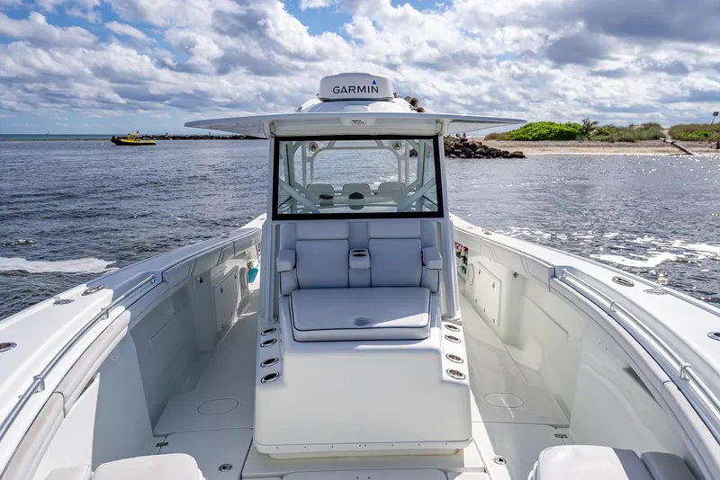 Slide: The Image of 2018 Yellowfin 42 boat with Garmin equipment, docked near a sandy beach under cloudy skies. - 42