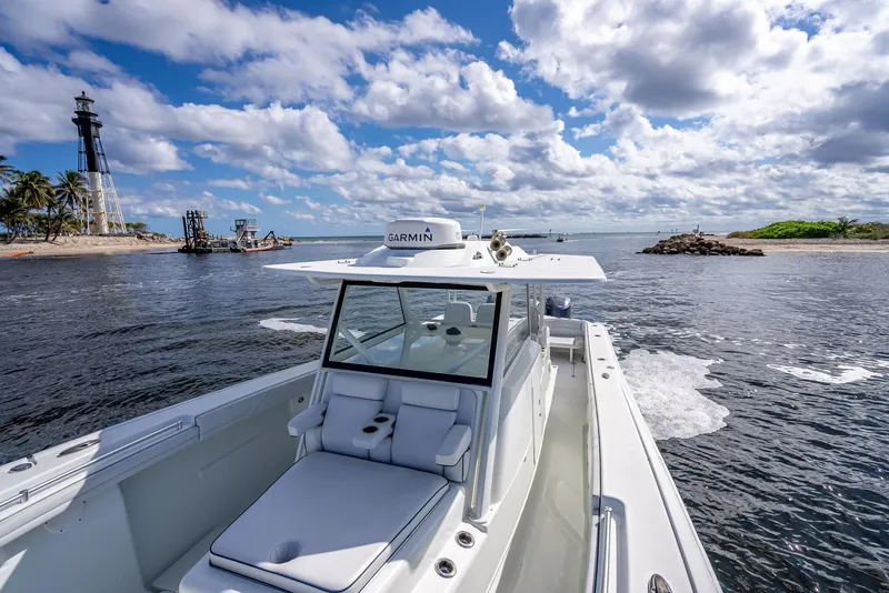 Slide: The Image of 2018 Yellowfin 42 boat cruising near a lighthouse under a partly cloudy sky. - 46