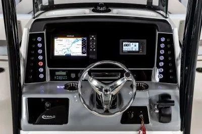 Slide: The Image of 2025 Robalo R232EXP boat dashboard with steering wheel, navigation screens, and control panel. - 4