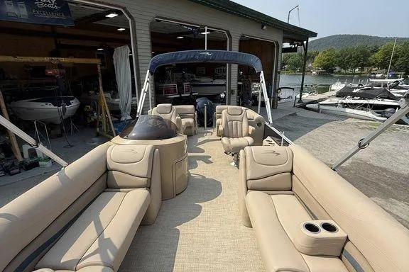 Slide: The Image of 2018 Bennington 23GSRFB pontoon boat with beige seating, docked near a marina. - 12