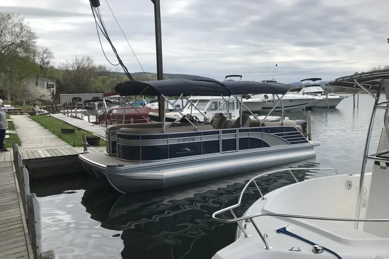 Slide: The Image of 2018 Bennington 23GSRFB pontoon boat docked at a marina on a cloudy day. - 15