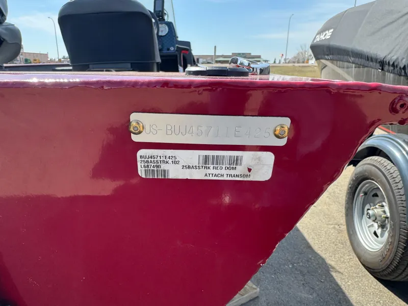 Slide: The Image of 2025 Tracker Bass Tracker Classic XL boat with identification plate, red exterior, parked outdoors. - 13