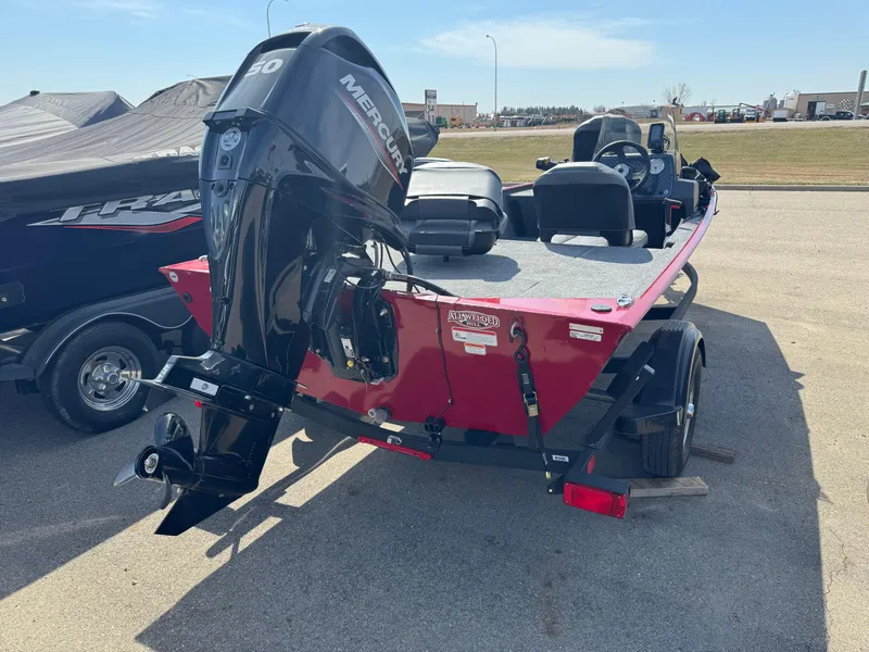 Slide: The Image of 2025 Tracker Bass Tracker Classic XL boat with Mercury engine, parked outdoors. - 2