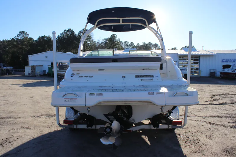 Slide: The Image of 2016 Sea Ray 240 Sundeck boat, rear view, parked outdoors under clear sky. - 11