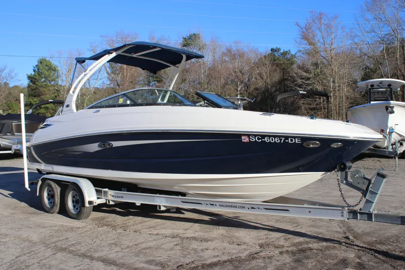 Slide: The Image of 2016 Sea Ray 240 Sundeck boat on trailer, parked outdoors. - 2