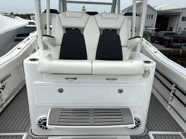 Slide: The Image of 2025 Tidewater 380 CC Adventure boat seating with sleek white and black design. - 12