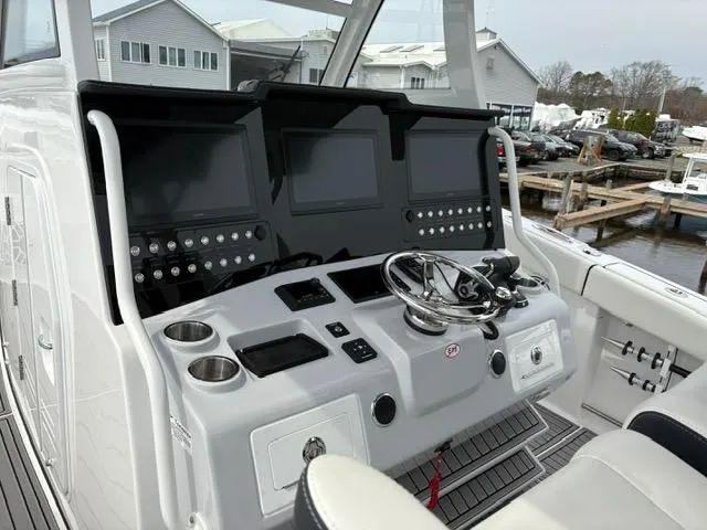 Slide: The Image of 2025 Tidewater 380 CC Adventure boat helm with dual screens and modern controls. - 5