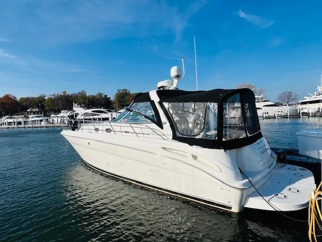 Slide: The Image of 2003 Sea Ray 380 Sundancer yacht docked in a marina under clear blue skies. - 0