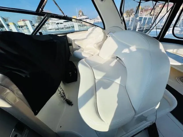 Slide: The Image of 2003 Sea Ray 380 Sundancer interior with white leather seating and marina view. - 13