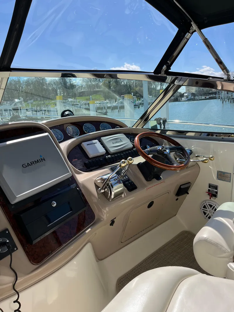Slide: The Image of 2003 Sea Ray 380 Sundancer helm with Garmin navigation, wood steering wheel, and control panel. - 15