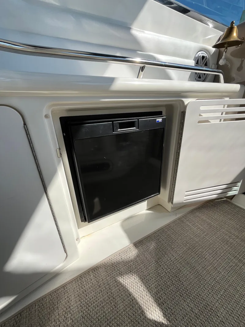 Slide: The Image of 2003 Sea Ray 380 Sundancer interior with built-in mini fridge and speaker. - 17
