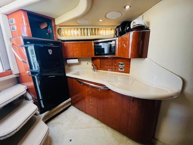 Slide: The Image of Luxurious 2003 Sea Ray 380 Sundancer yacht kitchen with modern appliances and elegant wood cabinetry. - 29