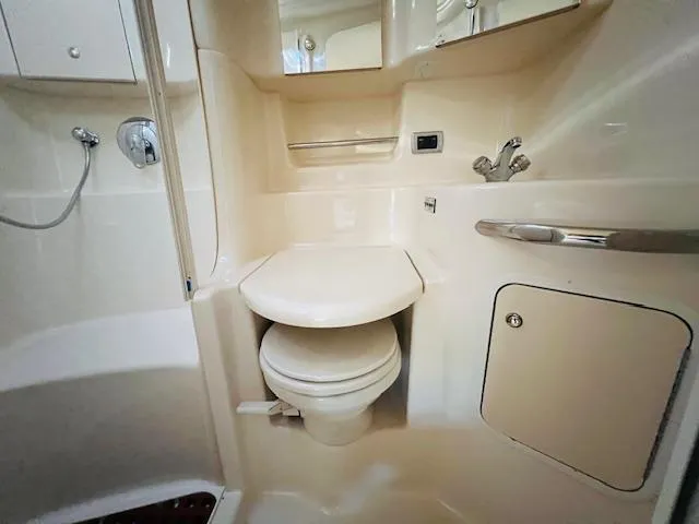 Slide: The Image of 2003 Sea Ray 380 Sundancer bathroom with toilet, shower, and storage cabinet. - 32