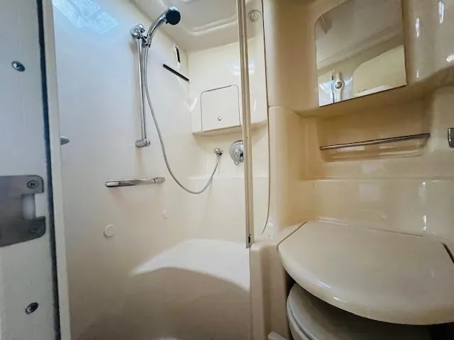 Slide: The Image of 2003 Sea Ray 380 Sundancer bathroom with shower, mirror, and storage. - 33