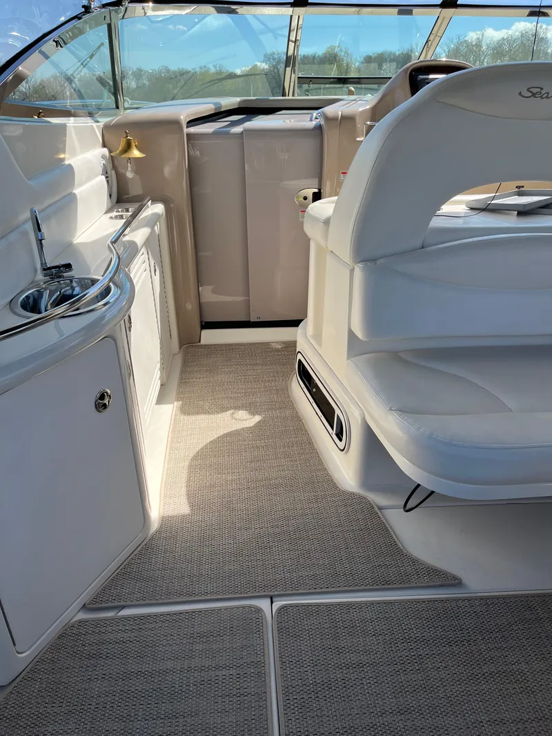 Slide: The Image of 2003 Sea Ray 380 Sundancer interior with helm, seating, and kitchenette. - 8