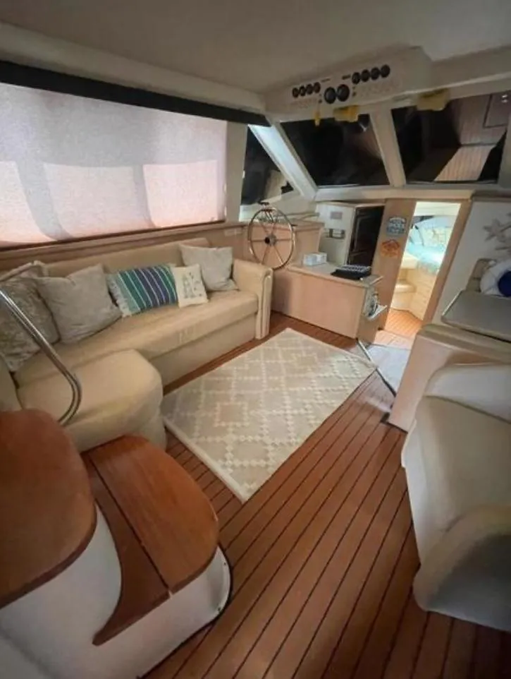 Slide: The Image of Interior of 1997 Carver 400 Cockpit Motor Yacht with cozy seating and wooden flooring. - 12