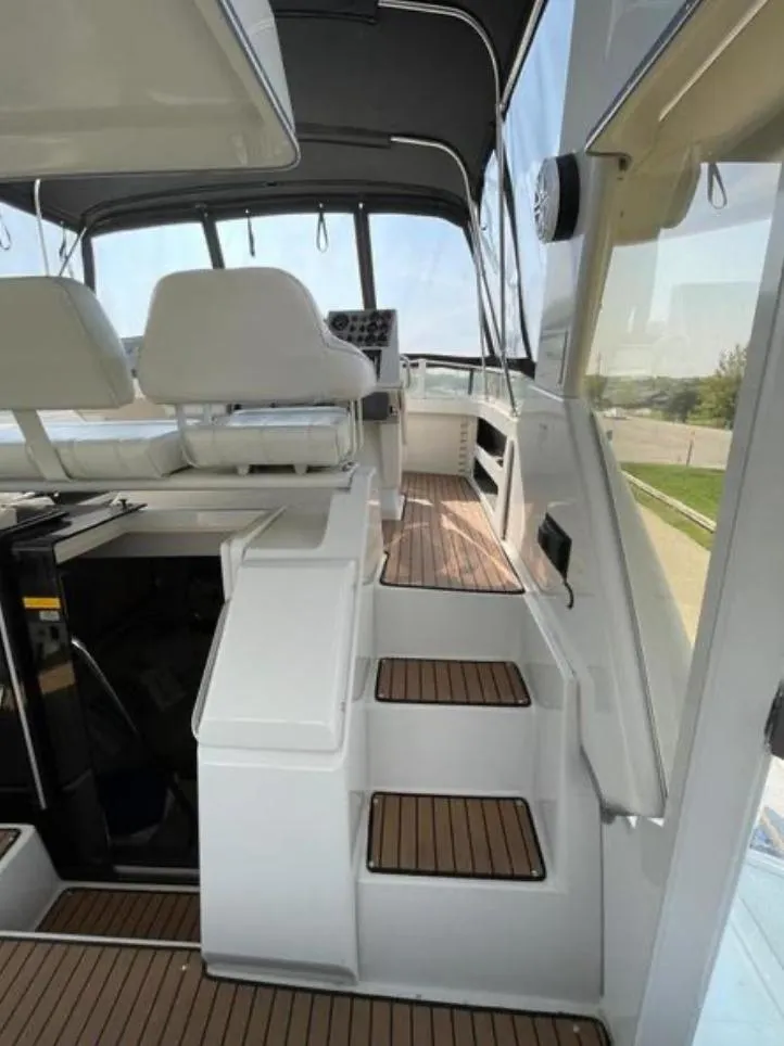 Slide: The Image of 1997 Carver 400 Cockpit Motor Yacht interior with helm, seating, and wooden steps. - 5