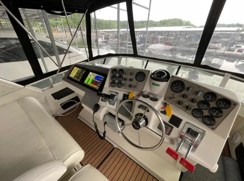 Slide: The Image of 1997 Carver 400 Cockpit Motor Yacht helm with modern navigation instruments and comfortable seating. - 7