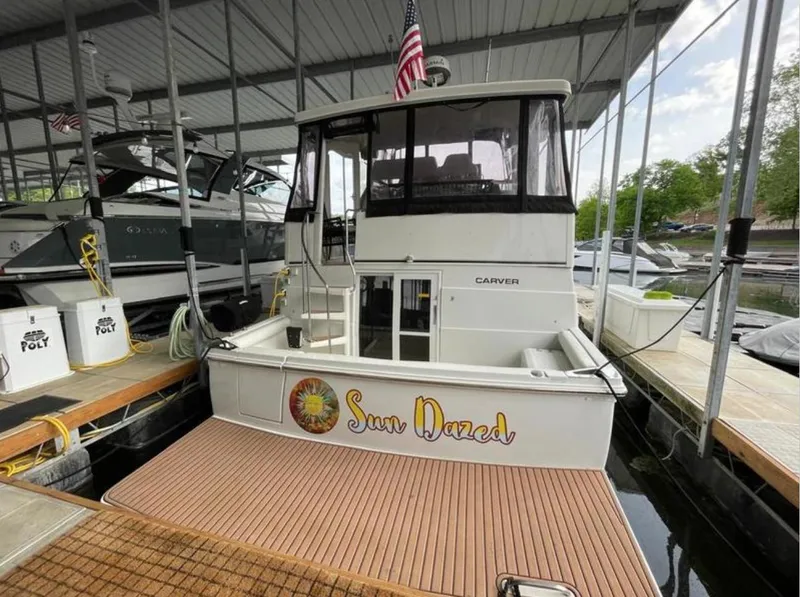 Slide: The Image of 1997 Carver 400 Cockpit Motor Yacht docked, named "Sun Dazed," with American flag. - 8