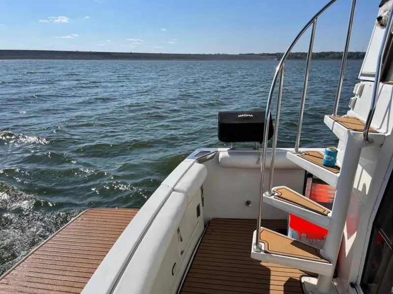 Slide: The Image of 1997 Carver 400 Cockpit Motor Yacht on open water, featuring a spacious deck and elegant stairs. - 9