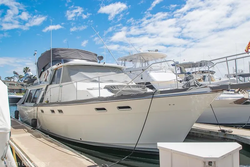 Slide: The Image of 1986 Bayliner 4588 Pilothouse yacht docked at marina under blue sky. - 1