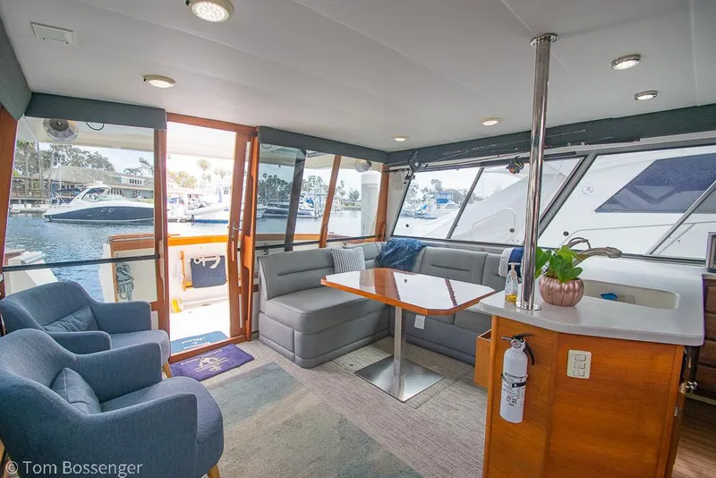 Slide: The Image of Interior of 1986 Bayliner 4588 Pilothouse yacht with seating, table, and marina view. - 11