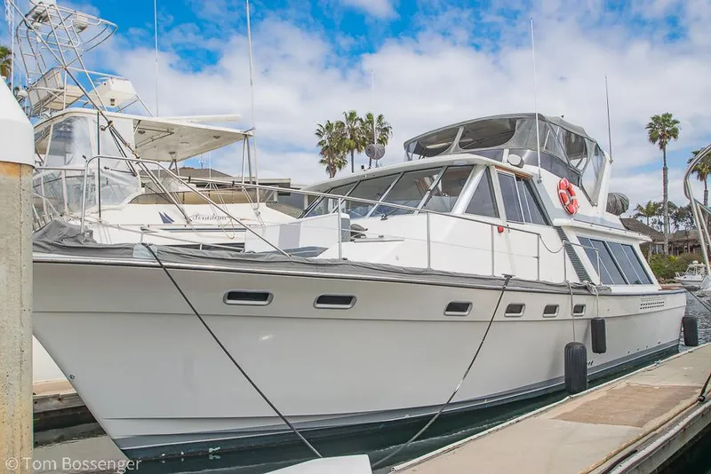 Slide: The Image of 1986 Bayliner 4588 Pilothouse yacht docked at marina under blue sky. - 2