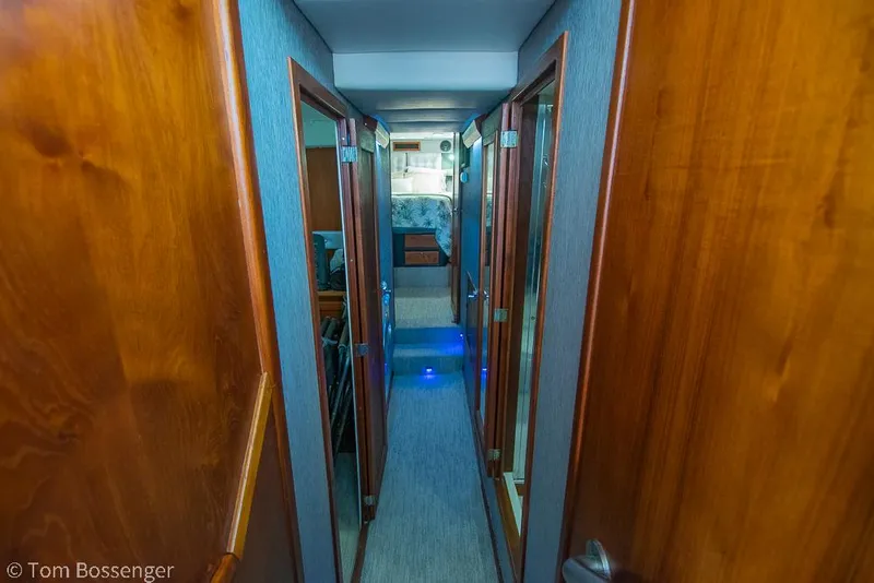 Slide: The Image of 1986 Bayliner 4588 Pilothouse interior hallway with wooden doors and modern lighting. - 20