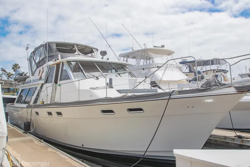 Slide: The Image of 1986 Bayliner 4588 Pilothouse yacht docked at marina under cloudy sky. - 3