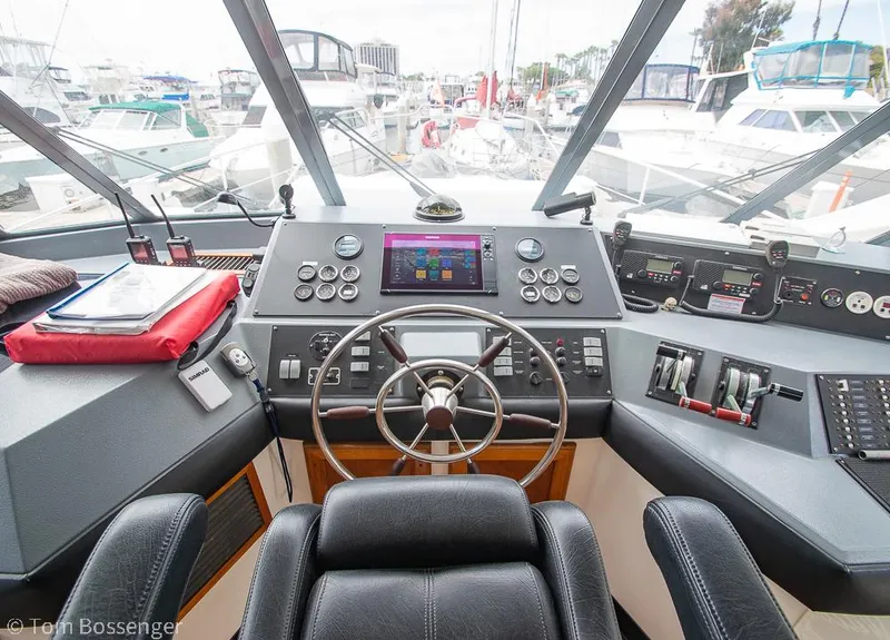 Slide: The Image of 1986 Bayliner 4588 Pilothouse helm with steering wheel, controls, and navigation equipment. - 33